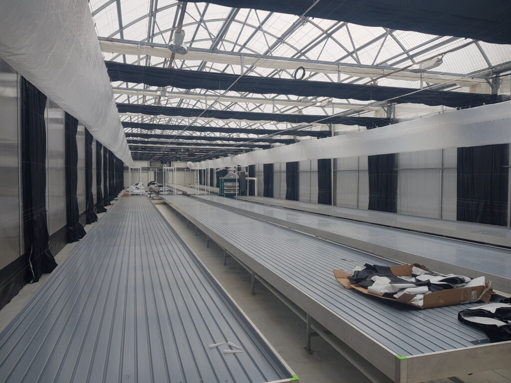 Australian medical cannabis greenhouse with triple blackout screens and aluminum ebb and flow benches